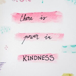 Motivational quote 'there is power in kindness' with colorful abstract design.